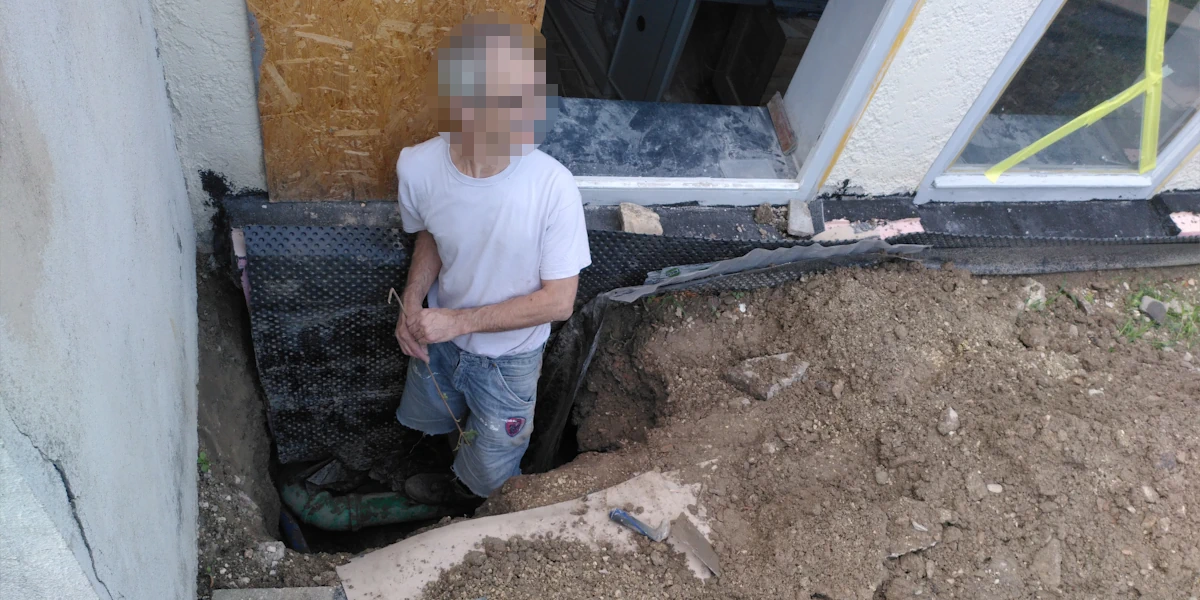 Ein Loch wird neben einer Außenwand gegraben