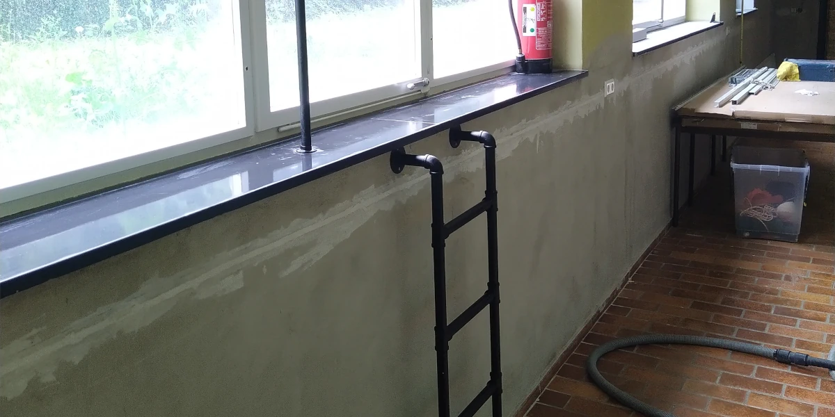 Schwarze Schimbadleiter unter dem Fluchtfenster