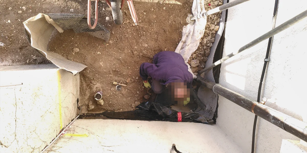 Im Graben werden Abdichtungsarbeiten durchgeführt