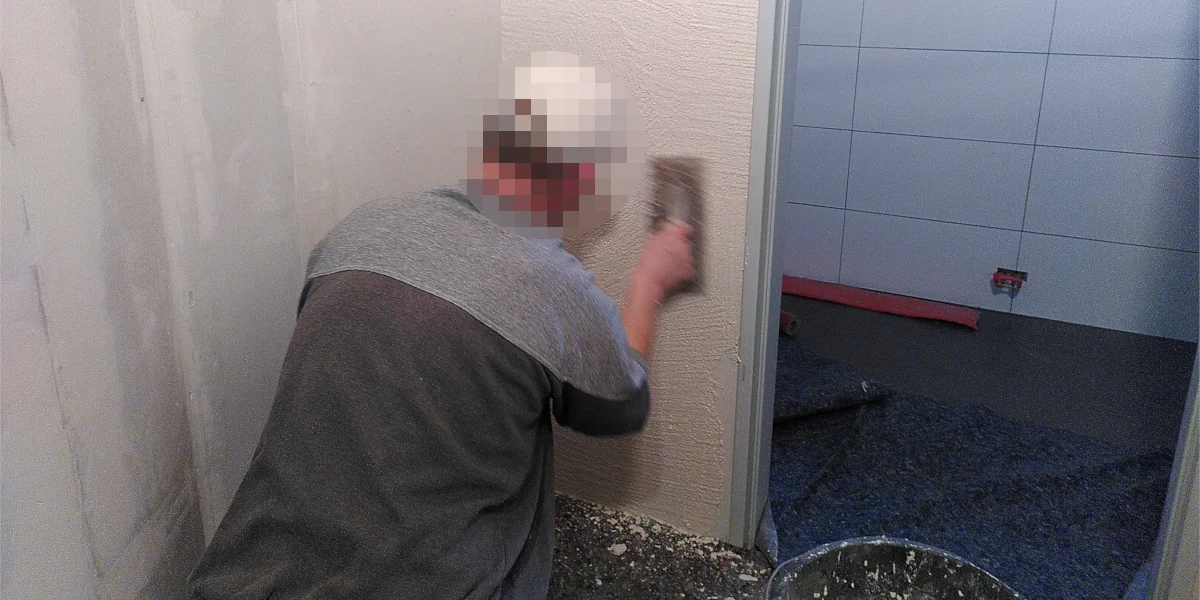 Schreibenputz wird an Toilettenwände angebracht